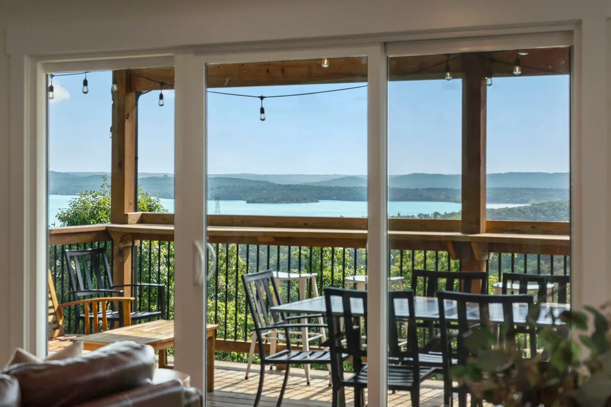 A tranquil deck with comfortable outdoor seating overlooking a peaceful water view and surrounding landscape. The setting is perfect for enjoying sunsets, al fresco dining, or simply unwinding in the fresh air.