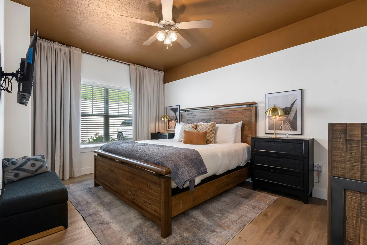 A serene multi-purpose room with a bed, window letting in natural light, nightstand, and an additional sofa. The space feels welcoming and adaptable, suitable for families or extra guests seeking flexibility and comfort.
